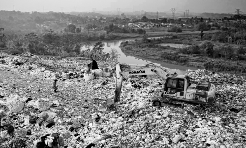 yellow-excavator-on-piles-of-trash